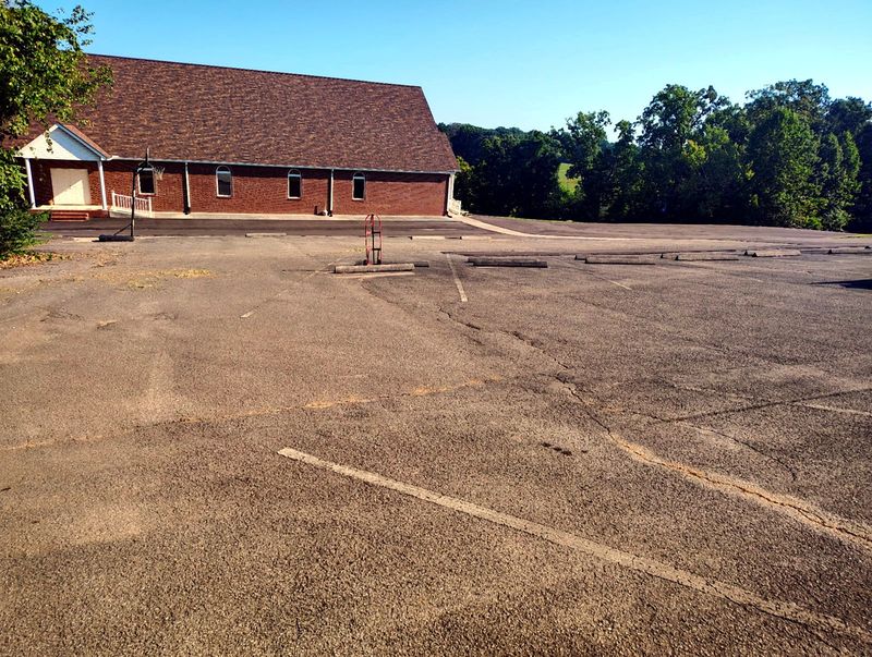 Weathered, faded commercial asphalt parking lot before sealcoating