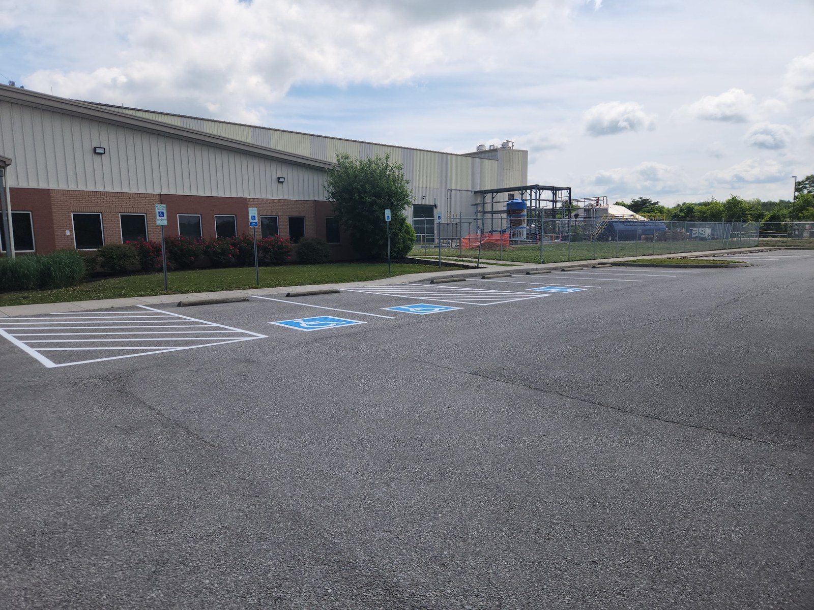 Completed white ADA parking lot striping at industrial building